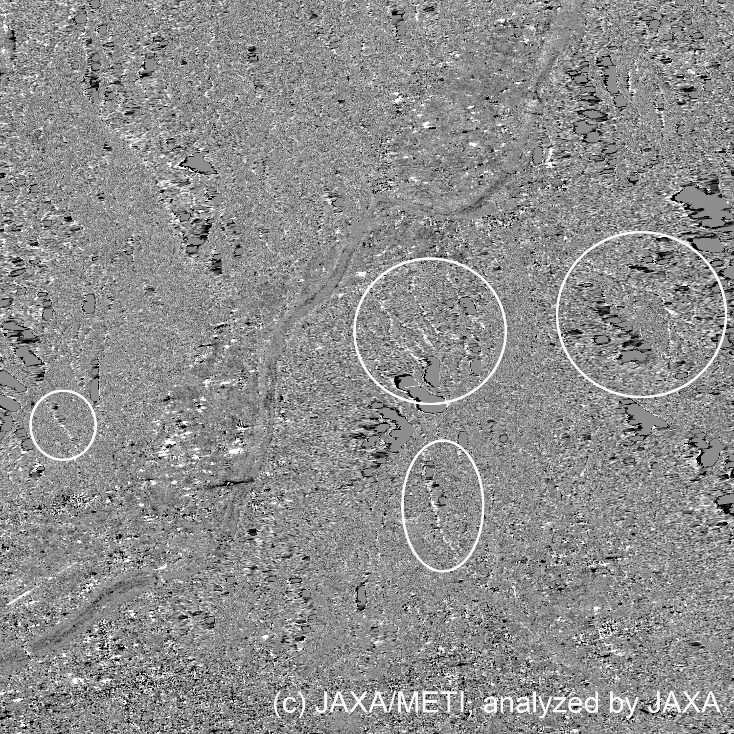 図3: 図2の2枚の画像を差分したもの。白丸内で、白く地形変化が見られる。白や黒でただれた傷跡のような箇所は、SARの正確に表せない領域を表す。また、一辺7.5kmの領域をあらわす。